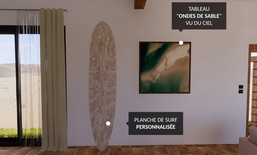 Dans l'espace salle à manger, le mur est décoré avec une planche de surf personnalisée appuyée sur la cloison. À côté se trouve le tableau "Ondes de sable" vu du ciel